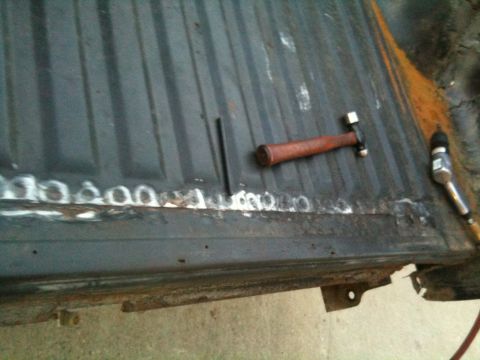 1993 Ford Bronco - Tools are laid out on a rusty truck bed, ready for repair work.