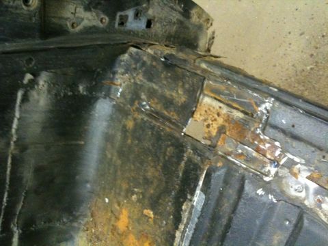 1993 Ford Bronco - Close-up view of heavily rusted metal framing, showing signs of repair with a welded patch.