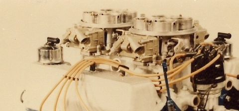 1973 Ford Mustang - Close-up view of a dual carburetor setup with a distributor and yellow spark plug wires, likely from a performance engine.