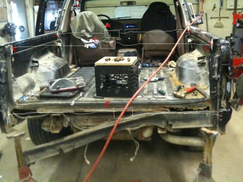 1993 Ford Bronco - The interior and cargo area of a truck, showing tools and a milk crate, with visible rust and damage.