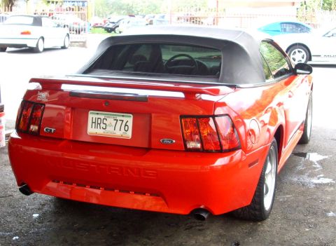 2002 Ford Mustang - Rear view of a red 2002 Ford Mustang GT convertible with a black soft top. The license plate reads HRS 776.