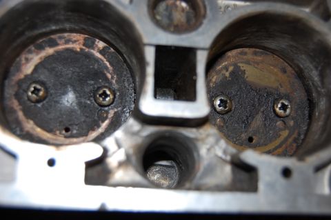 1994 Ford Bronco - Close-up of an engine cylinder head shows carbon deposits on the valves, creating a face-like appearance.