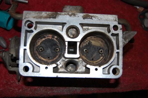 1994 Ford Bronco - Carburetor part showing internal throttle plates and stamped markings.