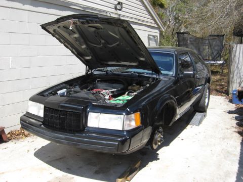 1990 Lincoln Mark VII - This 1990 Lincoln Mark VII is up on ramps with its hood open and front wheels off.