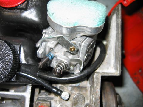 1992 Ford Bronco - Close-up view of a carburetor assembly, likely from a small engine, an air filter and associated linkage.