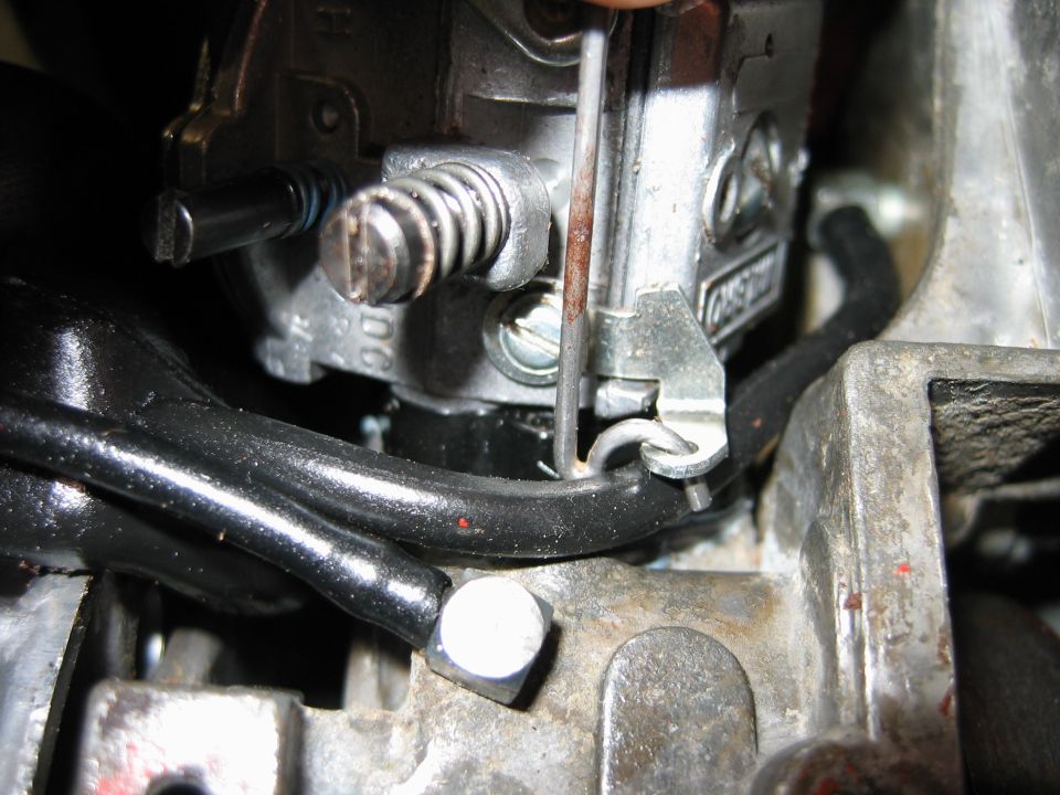 Macro of small engine carburetor throttle linkage, idle screw and fuel line