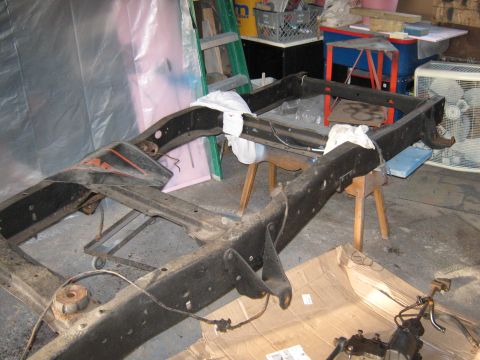 1977 Ford F-150 - A truck frame is shown disassembled in a garage setting, awaiting restoration.