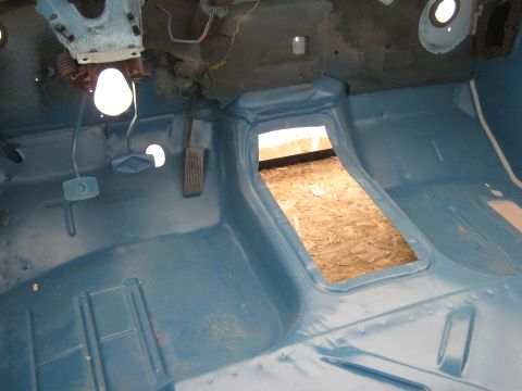 1977 Ford F-150 - The interior floor of a truck is painted blue, showing the transmission tunnel opening and pedals.