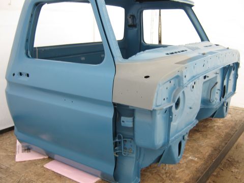1977 Ford F-150 - The front clip and cab of a blue Ford F-Series truck are shown, with some areas prepped with primer for paint.