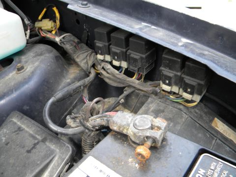 1993 Dodge Grand Caravan - Close-up view of a vehicle's battery terminal and electrical relays, showing signs of wear and corrosion.