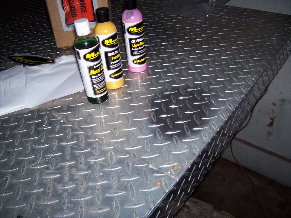 three bottles of metal polish on diamond plate surface