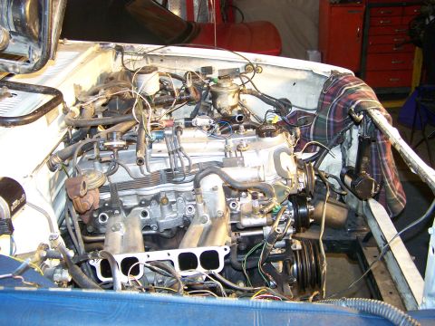 1988 Suzuki Samurai - The engine bay of a vehicle is shown with various mechanical parts and wiring exposed.