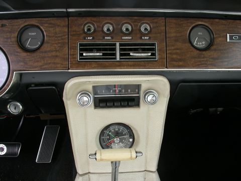1968 Mercury Cougar - The interior of a 1968 Mercury Cougar features wood grain trim, a Philco radio, and multiple gauges including oil pressure and temperature.