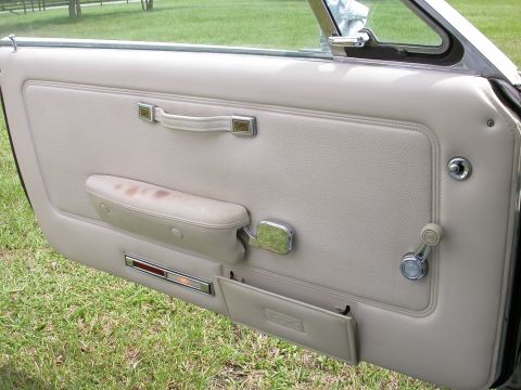 1968 Mercury Cougar - Interior view of a 1968 Mercury Cougar's driver's side door panel, showing the armrest and window crank.