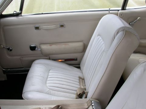 1968 Mercury Cougar - Interior view of a 1968 Mercury Cougar, showing the white seats and door panel details.