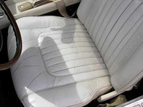 1968 Mercury Cougar - Interior view of white leather bucket seats and seatbelt.