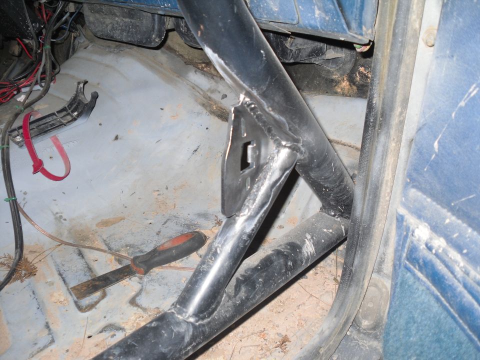 Roll cage inside a vehicle with a screwdriver on the floor