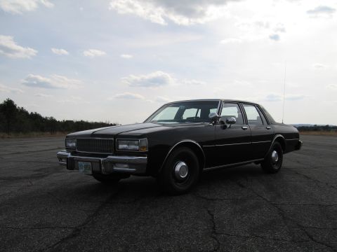 1991 Ford Crown Victoria LTD - This black sedan, likely from the early 1980s, is shown from a 3/4 front angle. The license plate is visible and reads 298 6968.
