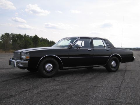 1991 Ford Crown Victoria LTD - This black sedan, seen from the side, appears to be from the early 1980s, not a 1991 Ford Crown Victoria LTD.