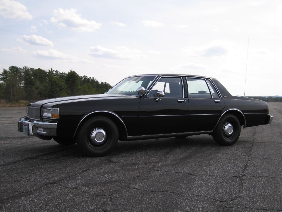 Black sedan, side view, circa 1980