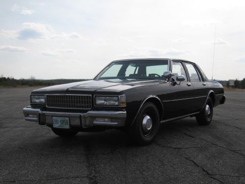 1991 Ford LTD Crown Victoria - This black sedan features a prominent chrome grille and a license plate reading 280 5858.
