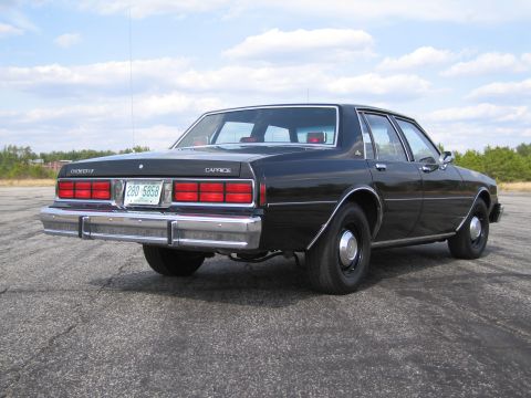 1991 Ford LTD Crown Victoria - Rear view of a black Chevrolet Caprice sedan, likely from the early 1980s.