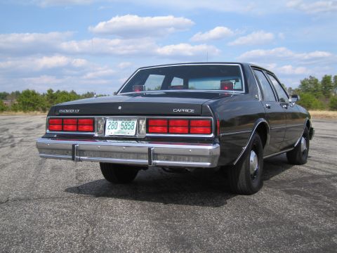 1991 Ford LTD Crown Victoria - Black 1980s Chevrolet Caprice sedan parked outdoors under a cloudy sky.
