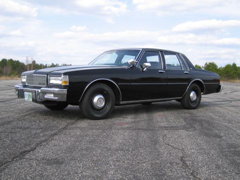 1991 Ford LTD Crown Victoria - This black sedan, likely from the early 1980s, is shown from a 3/4 front perspective on an asphalt surface.