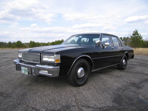 1991 Ford LTD Crown Victoria - This black sedan, likely from the early 1980s, is shown from a 3/4 front angle. The license plate is visible and reads 230 5958.