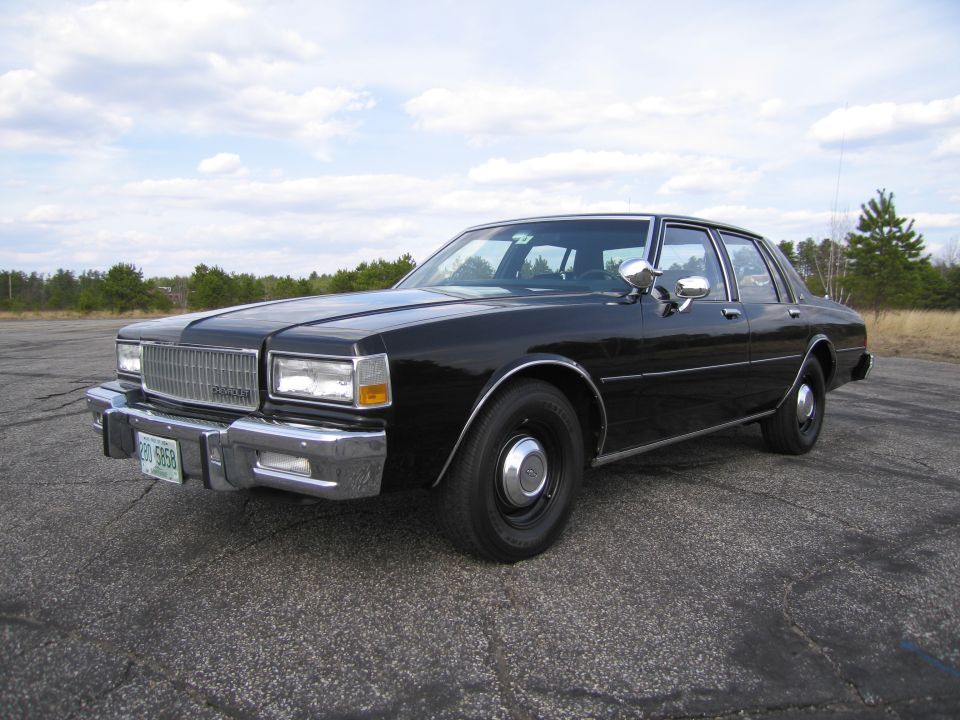 Black sedan, 3/4 front view. License plate reads 230 5958