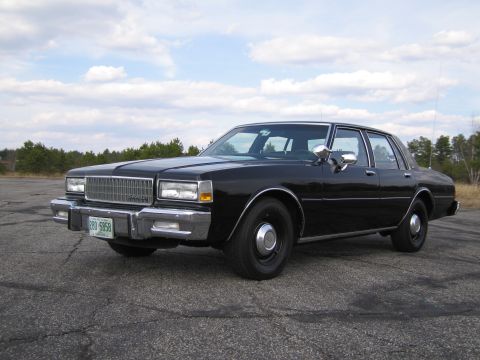 1991 Ford LTD Crown Victoria - This sedan features a prominent chrome grille and rectangular headlights, indicative of an earlier model year.