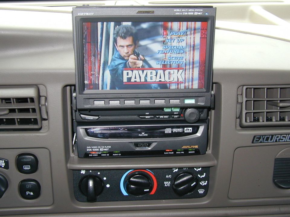 Alpine flip-out screen showing Payback DVD menu in Ford Excursion tan dash