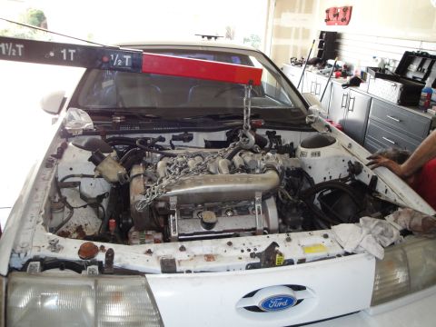 1989 Ford Taurus - Engine hoist positioned over the engine in a 1989 Ford Taurus.