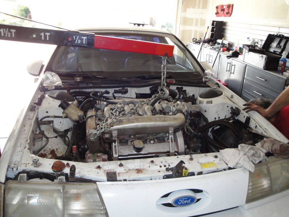 1989 Ford Taurus engine bay with engine hoist over the engine
