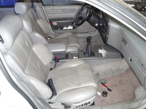 1989 Ford Taurus - The interior of a 1989 Ford Taurus is visible, with worn gray leather seats and a standard dashboard layout.