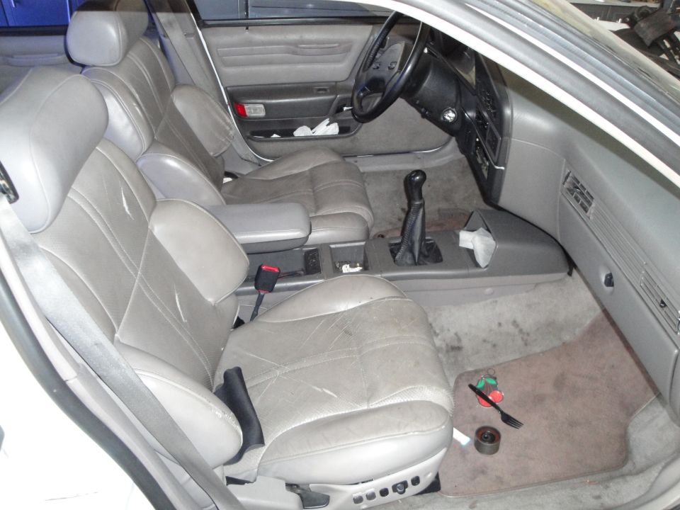 Gray leather interior of a 1989 Ford Taurus, showing front seats, dashboard, and center console