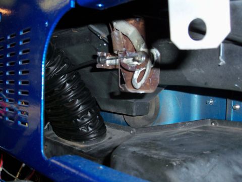 1978 Jeep CJ5 - Close-up of a blue Jeep's interior, showing a black flexible heater duct and mechanical linkage.