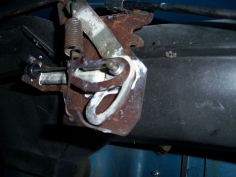 1978 Jeep CJ5 - This is a close-up view of a vehicle's throttle linkage mechanism, showing its rusty metal components and a spring.