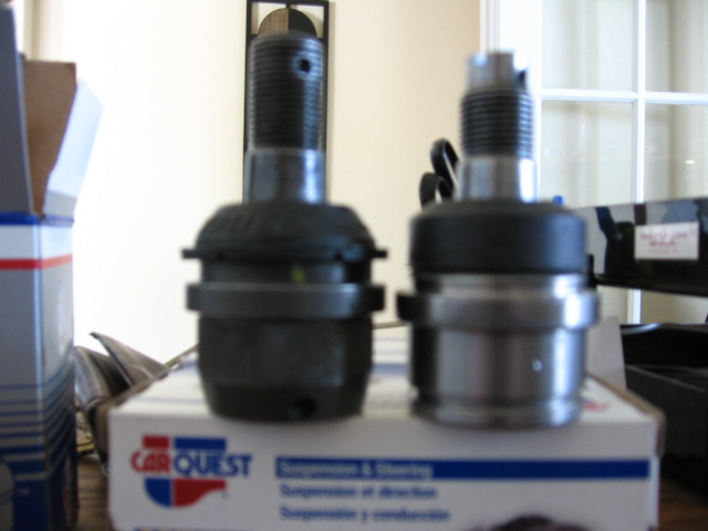 Old and new ball joints on a CarQuest suspension parts box.