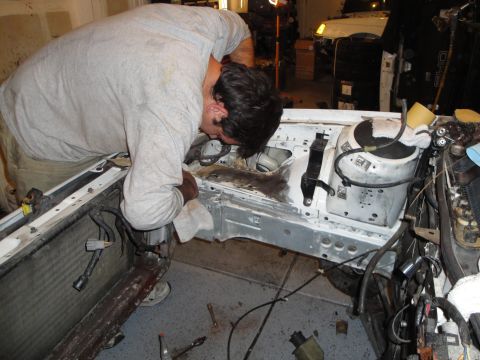 1989 Ford Taurus - Working on the engine bay of a car, cleaning components during a repair process.