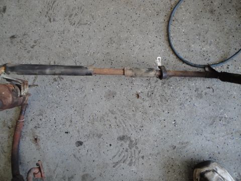 1989 Ford Taurus - A section of an exhaust pipe, likely removed for an engine swap, lies on a concrete surface.