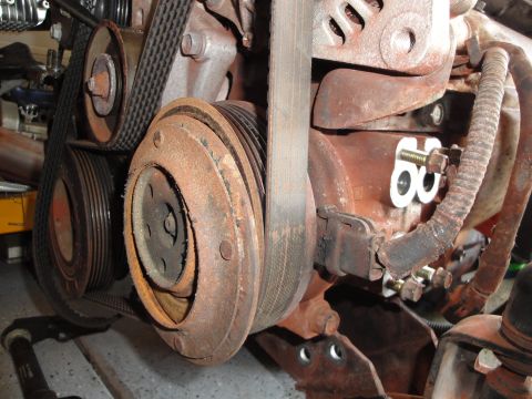 1989 Ford Taurus - The engine compartment shows a complex arrangement of belts and pulleys, indicating a functional engine component.