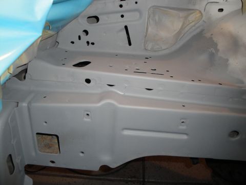 1989 Ford Taurus - Car chassis undergoing repair with gray primer applied to metal components.