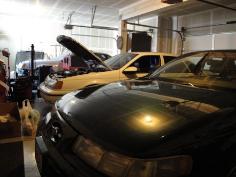 1989 Ford Taurus - A 1989 Ford Taurus is parked in a garage with its hood open, revealing the engine bay.