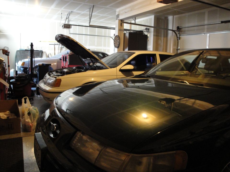 1989 Ford Taurus with hood open, parked in a garage