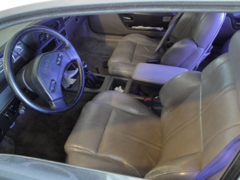 1989 Ford Taurus - The interior of a 1989 Ford Taurus is visible, tan leather seats and the dashboard.