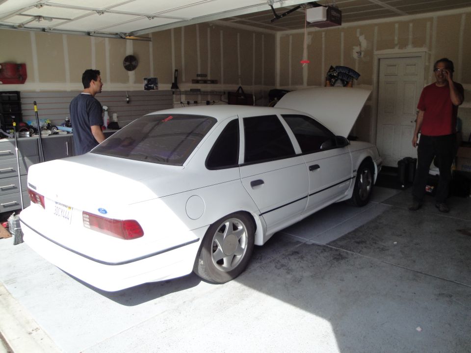 White 1989 Ford Taurus sedan with hood open in a garage
