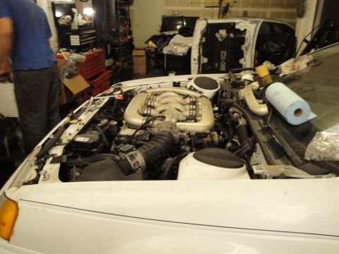 1989 Ford Taurus - The engine bay of a 1989 Ford Taurus, showing the V6 engine during what appears to be maintenance or an engine swap.