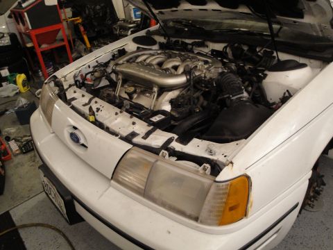 1989 Ford Taurus - Front view of a 1989 Ford Taurus engine bay, highlighting the V6 engine and intake system.
