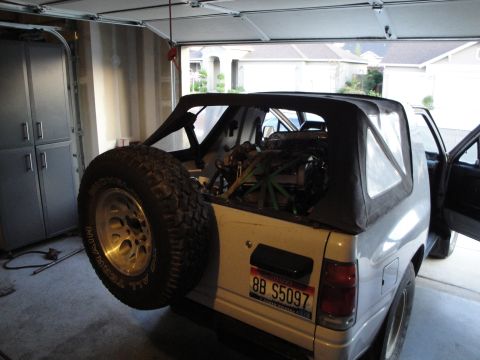 1989 Ford Taurus - This SUV, with its spare tire mounted externally, reveals its engine bay from the rear.